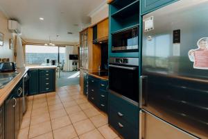 a kitchen with blue cabinets and a stainless steel refrigerator at Mt Taranaki Vista 