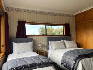 a bedroom with two beds and a window at Mt Taranaki Vista 