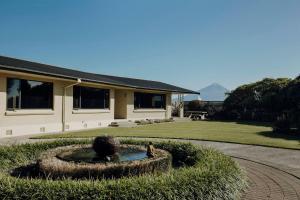 a house with a fountain in the middle of a yard at Mt Taranaki Vista 