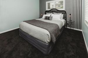a bedroom with a large bed with a black headboard at Buller Noire Outstanding in New Plymouth