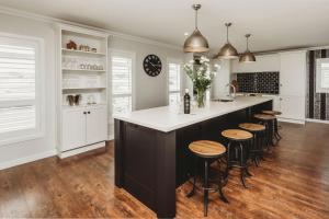 a kitchen with a black and white island with bar stools at Buller Noire Outstanding in New Plymouth