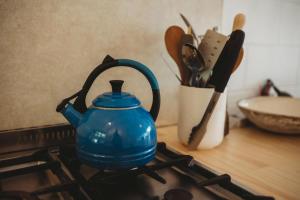 a blue tea kettle sitting on top of a stove at The Beach Retreat Sleeps 12 in Oakura