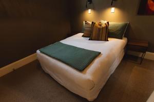 ein Schlafzimmer mit einem großen Bett mit grünen Kissen in der Unterkunft Stay Central The Loft in New Plymouth