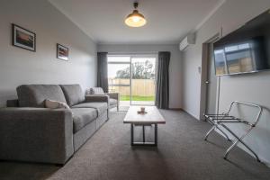 a living room with a couch and a table at The Flight Pad Window Seat Pet Friendly in Waitara