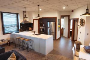 a kitchen with a white island in a living room at Stay Central The Penthouse in New Plymouth