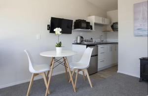 a small kitchen with a white table and chairs at Mountain View Ark Apartment in New Plymouth