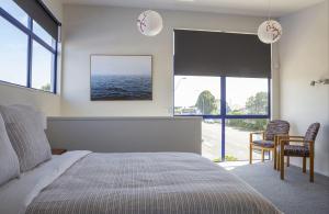 a bedroom with a bed and a view of the ocean at Mountain View Ark Apartment in New Plymouth