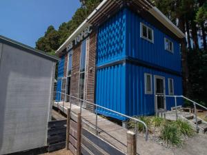 ein blaues Gebäude mit einer Rampe neben einem Haus in der Unterkunft The Eco Lodge Tsb Topec in Hillsborough