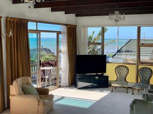 a living room with a tv and a large window at Blast On Hine in New Plymouth