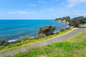 een weg langs de oceaan op een zonnige dag bij Seven By The Sea Tourist Hot Spot in New Plymouth