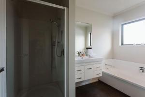 y baño con ducha y lavamanos. en Seven By The Sea Tourist Hot Spot, en New Plymouth