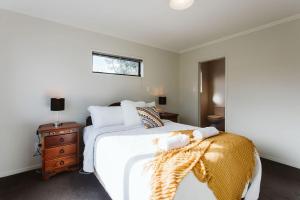 a bedroom with a large white bed and a window at Seven By The Sea Tourist Hot Spot in New Plymouth
