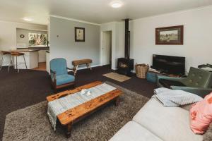 a living room with a couch and a coffee table at Wharepuni Oakura Retreat in Tataraimaka