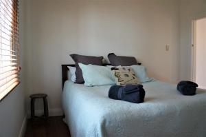 a bedroom with a bed with blue sheets and pillows at The Buller Bungalow You Will Fall In Love in New Plymouth