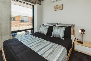 a bedroom with a large bed with a large window at One50 Molesworth L1 - Sleeps 6 in New Plymouth