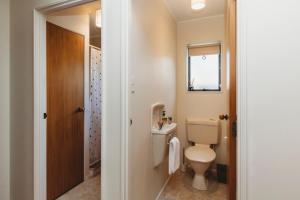 a bathroom with a toilet and a sink at The Gilbert Getaway in New Plymouth