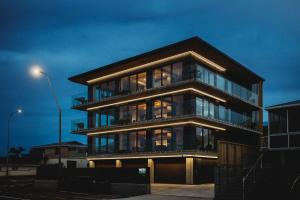 a large building with glass windows at night at One50 Molesworth L1 - Sleeps 6 in New Plymouth