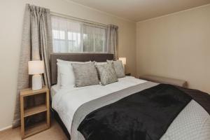 a bedroom with a large bed and a window at The Gilbert Getaway in New Plymouth