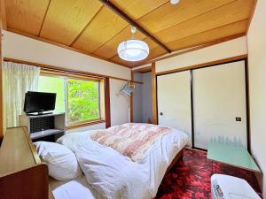 a bedroom with a bed and a large window at Nakanoya in Nanto