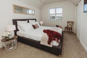 a bedroom with a large bed with a red blanket on it at Fox Manor - High-end Quality in New Plymouth