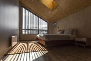 1 dormitorio con cama y ventana grande en The Natural Home Prime Fitzroy Location, en New Plymouth