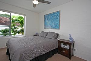a bedroom with a bed and a table and a window at Quarterdeck 8 in Lennox Head