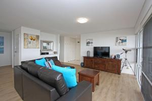 a living room with a couch and a television at Quarterdeck 8 in Lennox Head