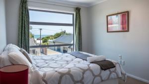 a bedroom with a bed and a large window at Magic On Molesworth Wow Factor Prime Location in New Plymouth