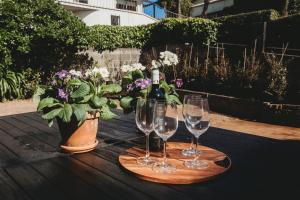 una mesa con copas de vino y un jarrón con flores en Fox Manor - High-end Quality en New Plymouth