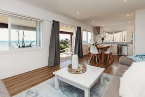 a living room with a couch and a table at Wow On Wanaka Bay in New Plymouth