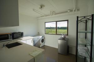 uma cozinha com um lavatório e um micro-ondas em Wills On The Water Beachfront Apartment em Bell Block