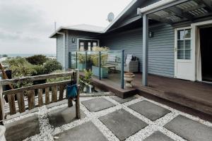 a house with a wooden deck with a porch at The lookout Central in New Plymouth