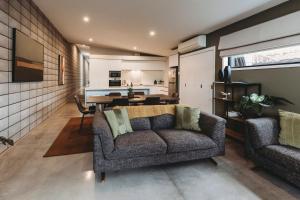 a living room with a couch and a dining room at Perfect On Powderham Prime Inner City Location in New Plymouth