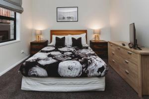 a bedroom with a bed with a black and white blanket at Perfect On Powderham Prime Inner City Location in New Plymouth