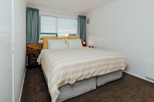 1 dormitorio con 1 cama grande y ventana en Wanaka Bay Waterfront en New Plymouth