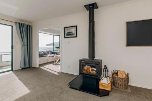 sala de estar con chimenea y TV en Wanaka Bay Waterfront en New Plymouth