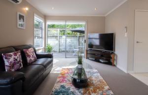 a living room with a couch and a television at Great Location On Gilbert Central in New Plymouth