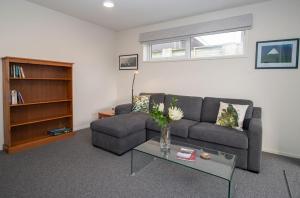 a living room with a couch and a table at By The Sea On Sackville Brand New Apartment in New Plymouth