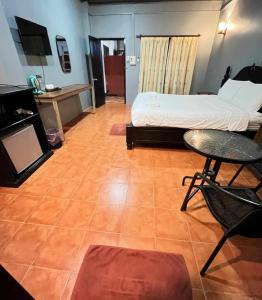 um quarto com uma cama, uma mesa e uma cadeira em Nice view guesthouse em Vang Vieng