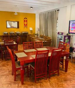 uma sala de jantar com uma mesa de madeira e cadeiras em Sadula Holiday Resort em Anuradhapura