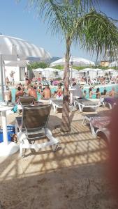 een groep mensen die op ligstoelen op het strand zitten bij All'Ombra Del Noce B&B in Catona
