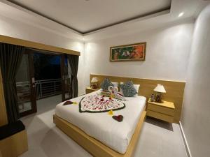 Un dormitorio con una cama con flores. en Kelingking Sunset Point Hotel & Spa, en Klungkung