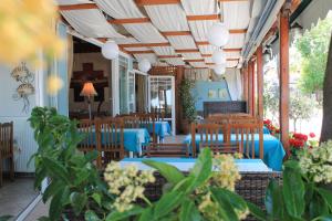 a restaurant with wooden chairs and tables and blue tables at Xaris in Platamonas