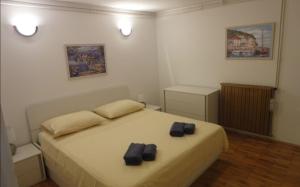 a bedroom with a bed with two black slippers on it at Apartments Maria - close to the beach in Split