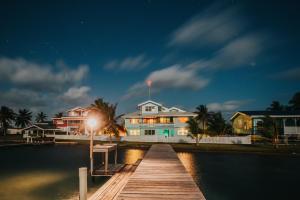 ein Haus auf einem Steg im Wasser in der Nacht in der Unterkunft Casa Al Mar, St. George's Caye - Belize in Belize City