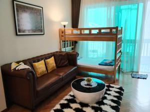a living room with a couch and a bunk bed at Penang Straits Quay Marina Suites By AuroraHomes in Bagan Jermal