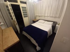 a bedroom with a bed with a blue and white blanket at Casa agradável com Piscina in São Paulo