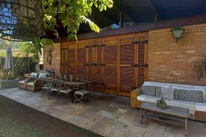 a patio with a table and chairs and a brick wall at Casa agradável com Piscina in Sao Paulo