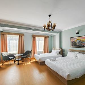 加德滿都的住宿－Boudha Apart Hotel，一间卧室配有两张床和一张桌子及椅子