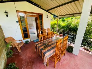 a patio with a table and chairs on a house at Mellow Homestay in Ella